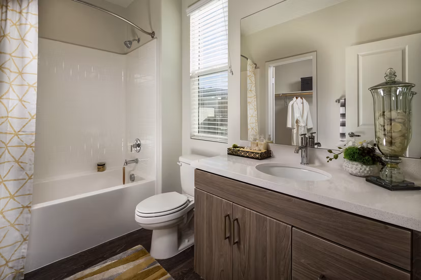 Modern bathroom with marble countertops and glass shower doors at Terrano Apartments