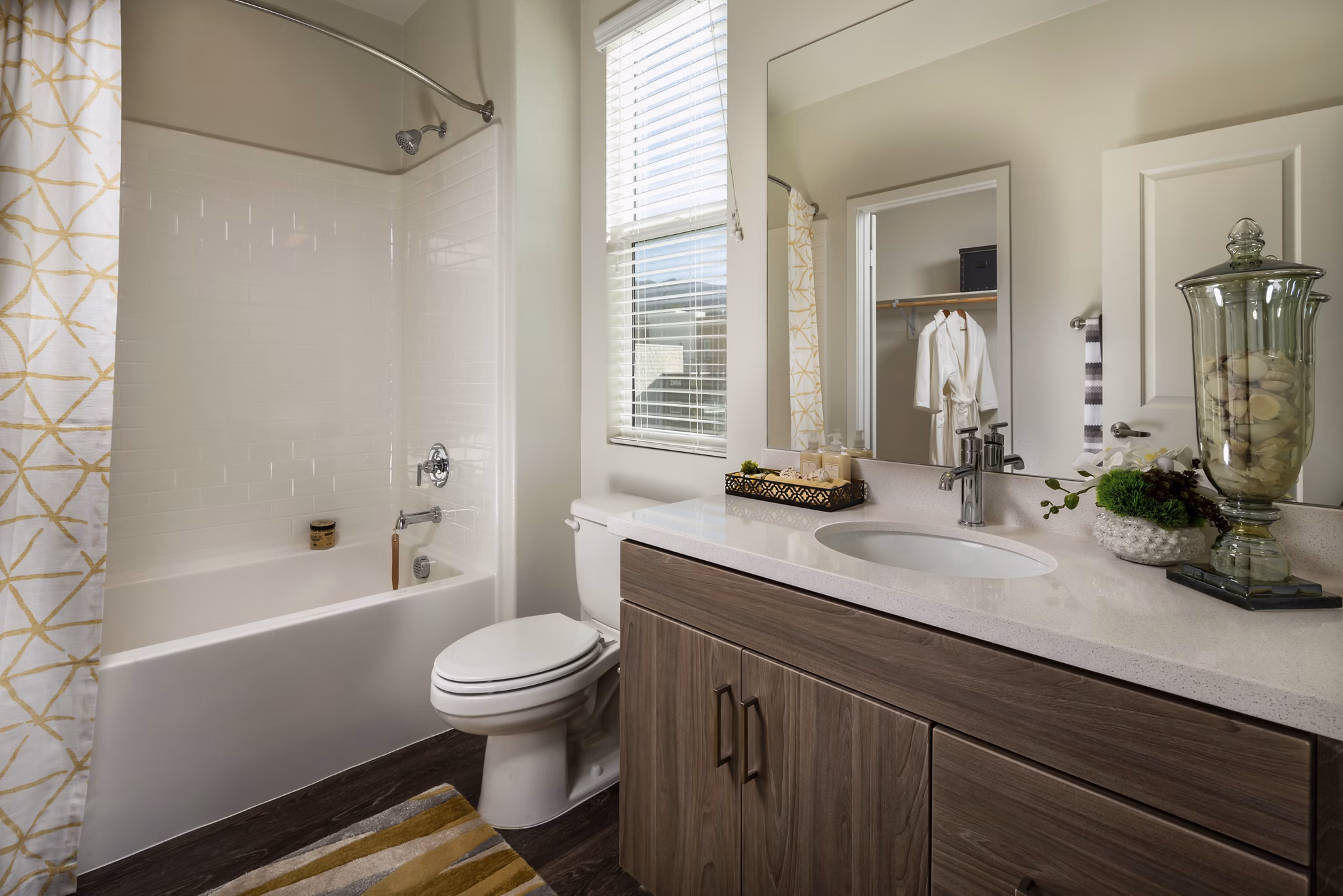 Modern bathroom with marble countertops and glass shower doors at Terrano Apartments