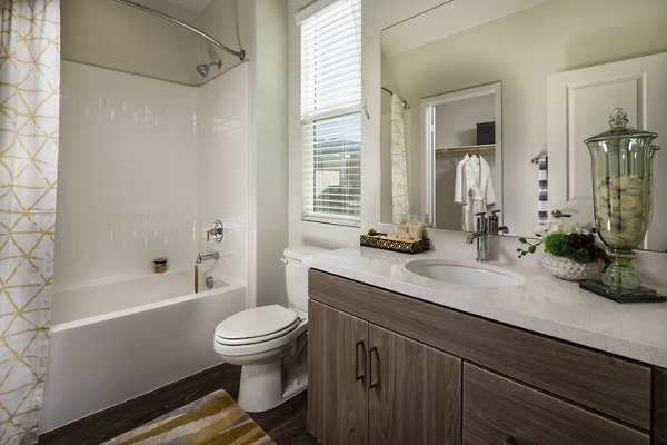 Modern bathroom with marble countertops and glass shower doors at Terrano Apartments