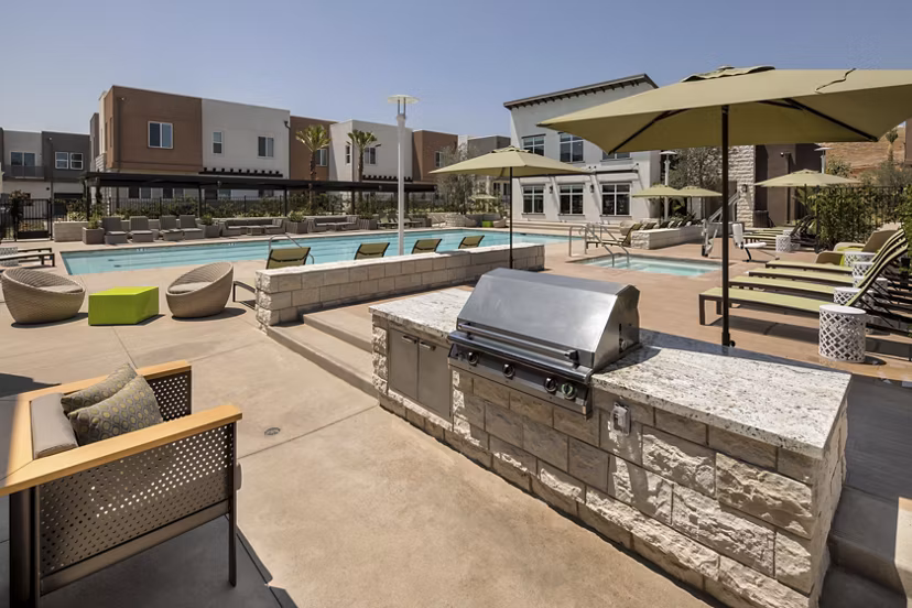 Outdoor grill and pool area at Terrano Apartments offering luxury amenities for residents