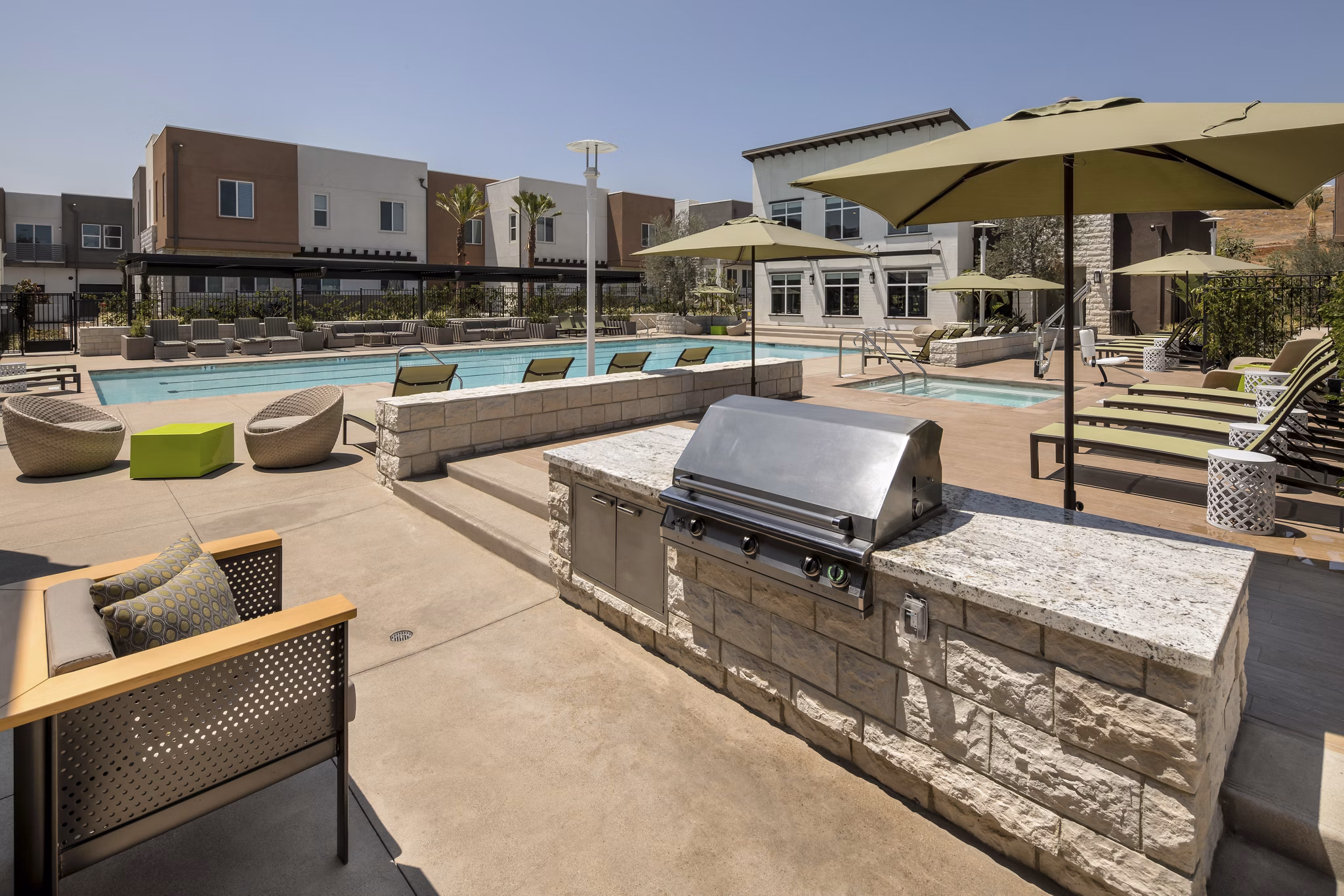 Outdoor grill and pool area at Terrano Apartments offering luxury amenities for residents