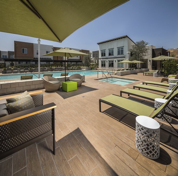 Resort-style pool at Terrano Apartments with lounging area and landscaped surroundings