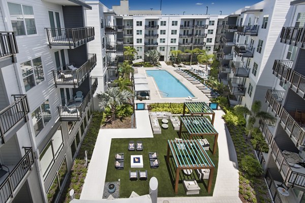 Riverside pool surrounded by lush greenery at Anchor Riverwalk Apartments, offering luxury relaxation space for residents