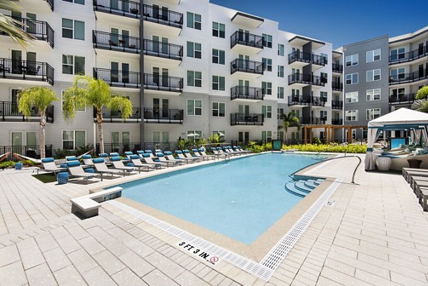 Resort-style pool with lush landscaping at Anchor Riverwalk Apartments, a luxury living community