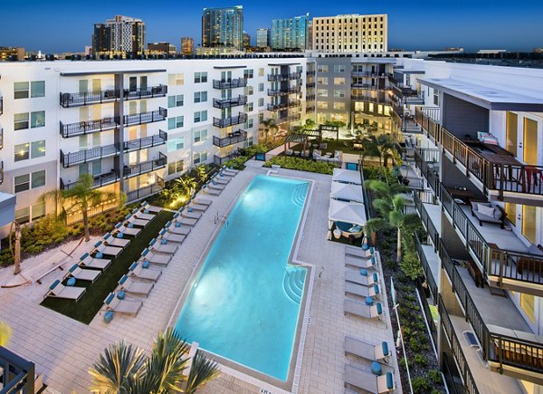 Poolside retreat at luxury Anchor Riverwalk Apartments with lounge chairs and lush landscaping