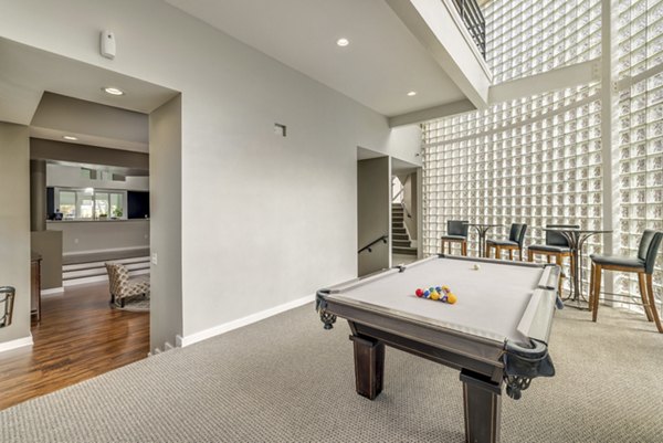 Lounge area with a pool table and bar stools in luxury apartments