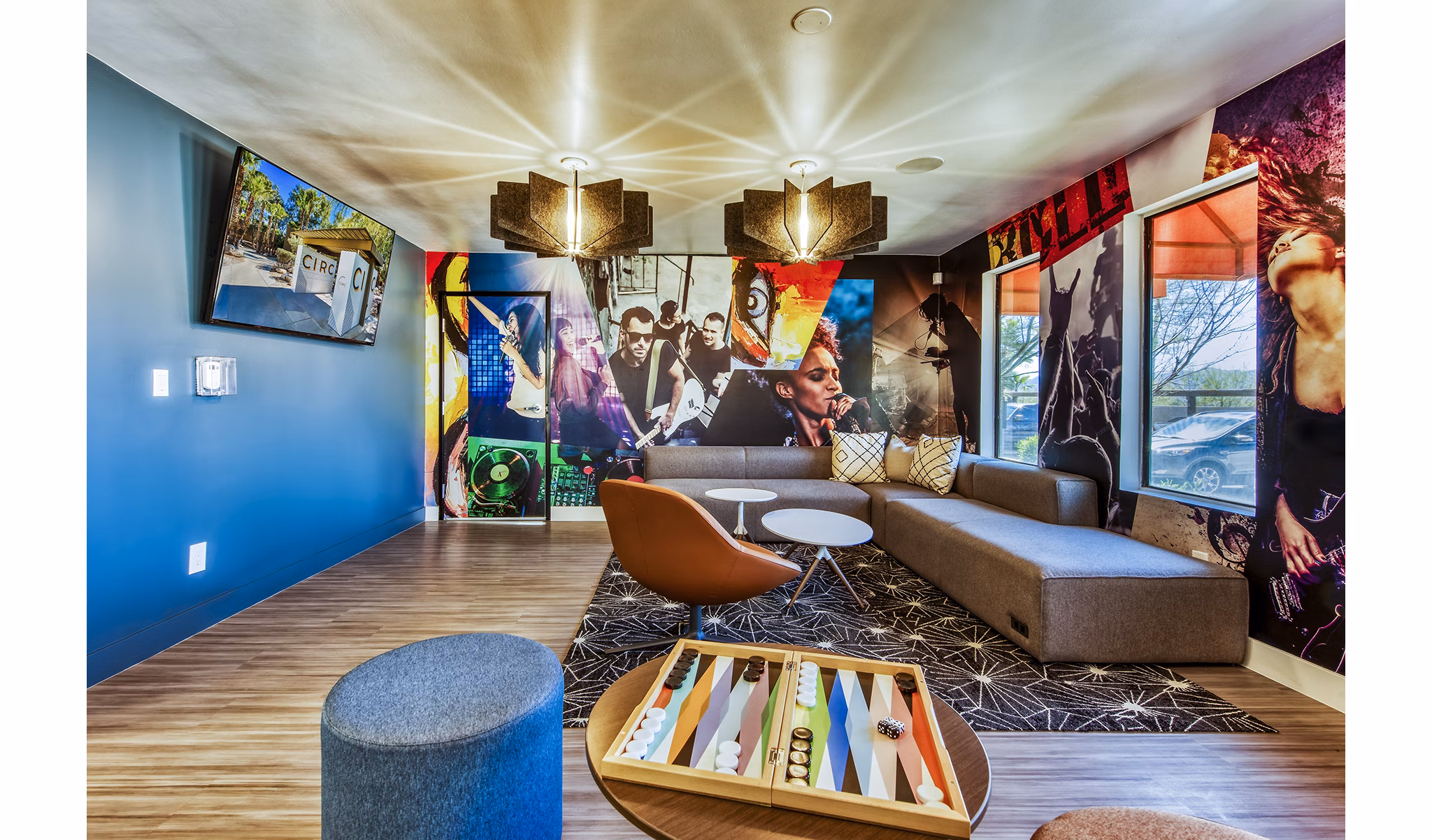Modern lounge area with colorful wall art, seating, and a backgammon board at luxury apartments