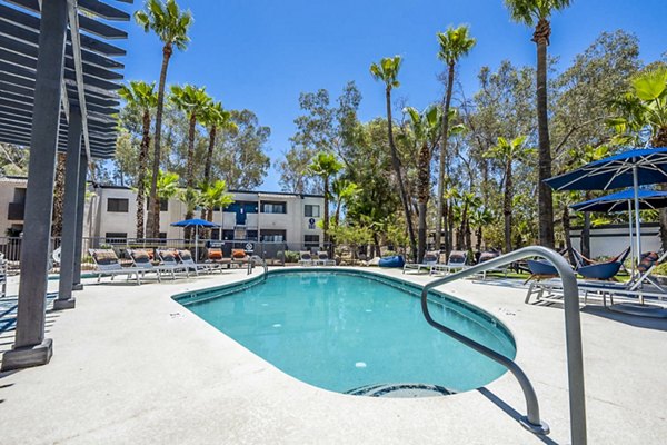 Modern outdoor pool with sun loungers at CIRC Apartments, offering luxury amenities for residents to enjoy leisure and relaxation