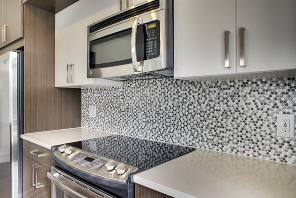 Modern kitchen with stainless steel appliances at 555 Ross Apartments
