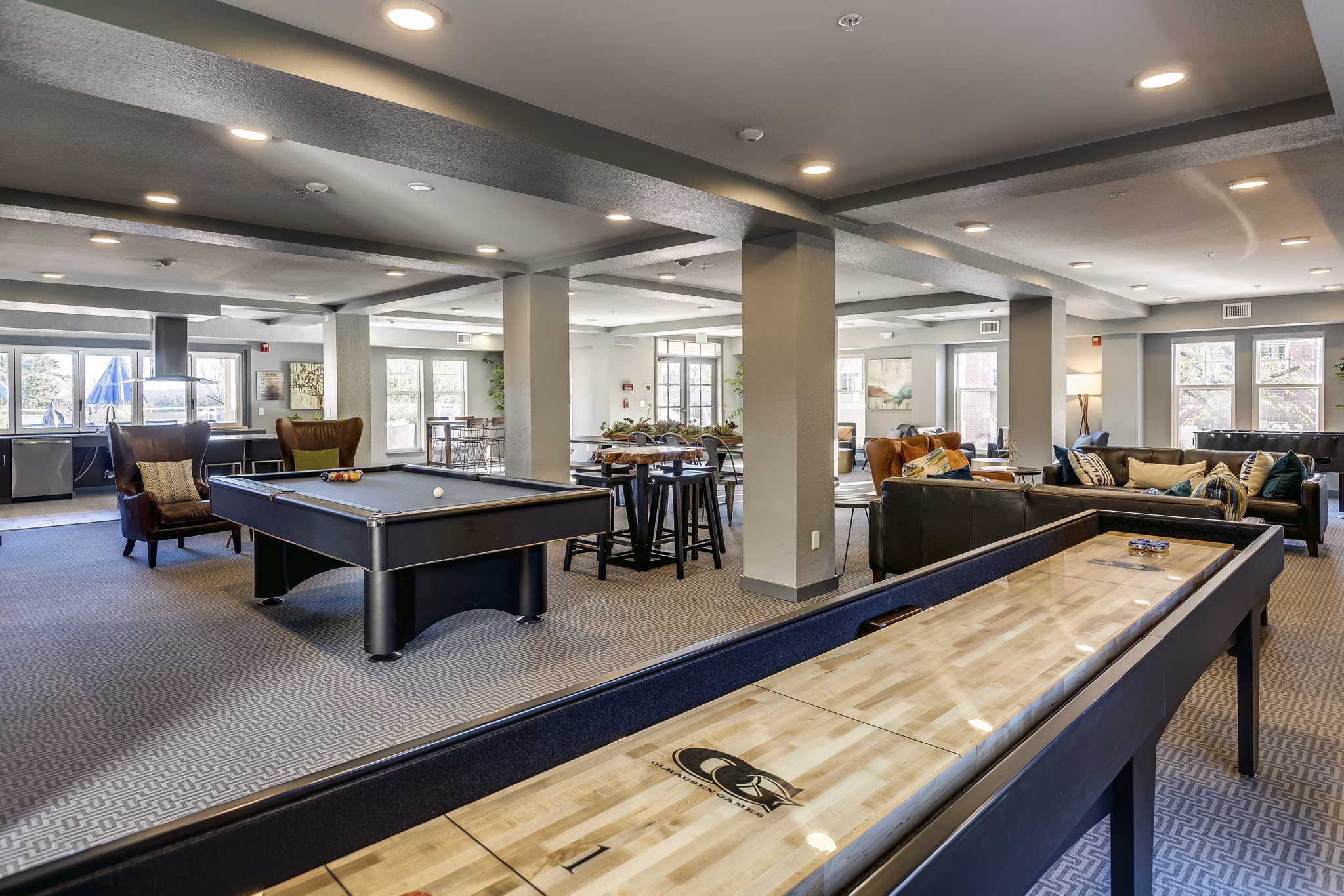 Game room with modern pool table and cozy seating area in Shorewood Heights Apartments, offering luxury community amenities for relaxation and entertainment
