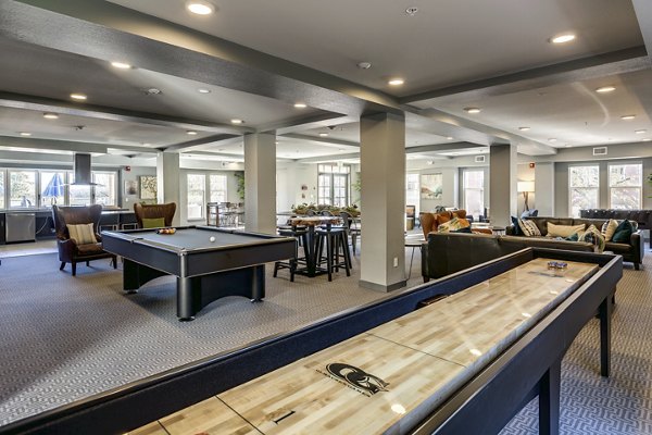 Game room with modern pool table and cozy seating area in Shorewood Heights Apartments, offering luxury community amenities for relaxation and entertainment