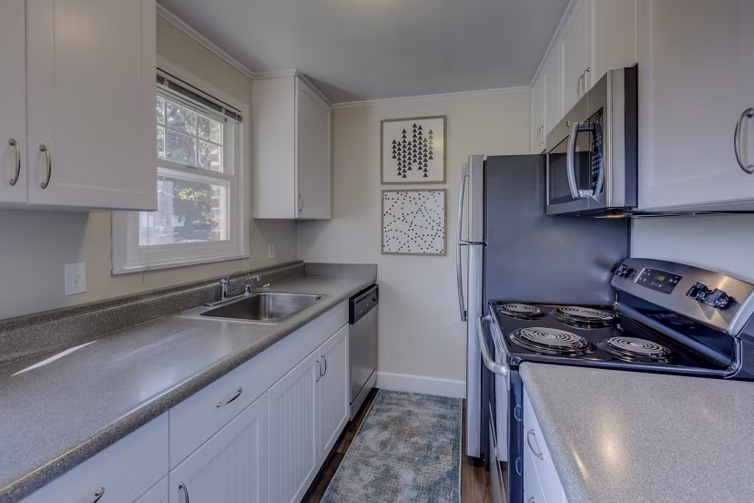 Modern kitchen with stainless steel appliances and sleek countertops at Shorewood Heights Apartments