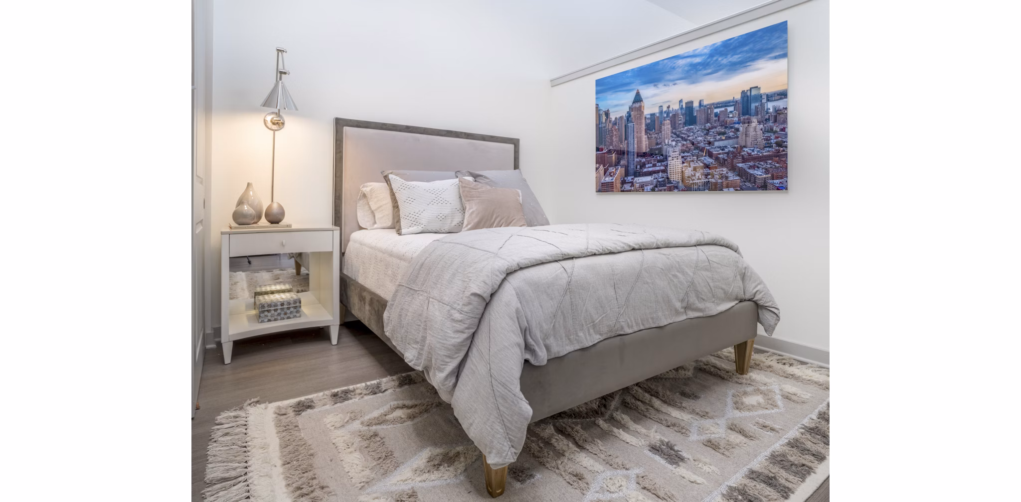 Cozy bedroom featuring modern decor and large windows at Main & Clay Apartments