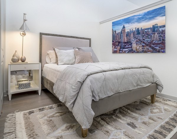 Cozy bedroom featuring modern decor and large windows at Main & Clay Apartments