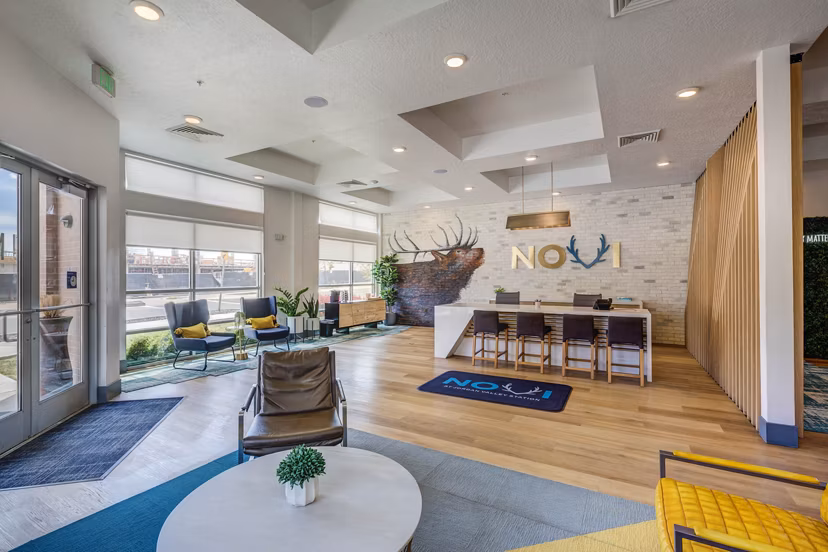 Clubhouse featuring a modern design and communal seating at Novi at Jordan Valley Station Apartments