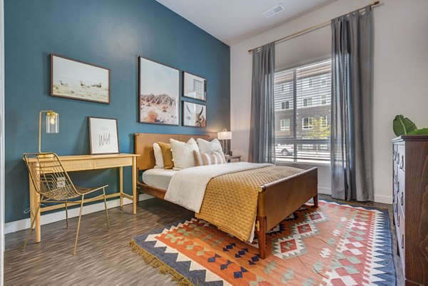 Cozy bedroom with modern design at Novi at Jordan Valley Station Apartments, featuring stylish decor and ample natural light for a luxurious living experience