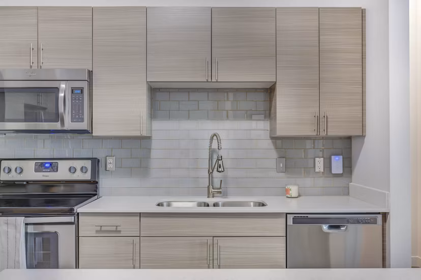 Modern kitchen with stainless steel appliances at Novi at Jordan Valley Station Apartments