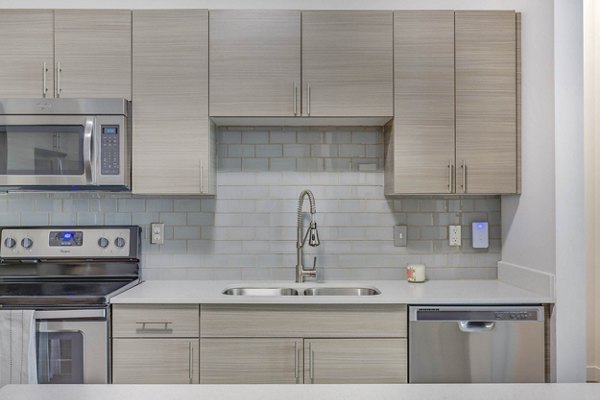 Modern kitchen with stainless steel appliances at Novi at Jordan Valley Station Apartments