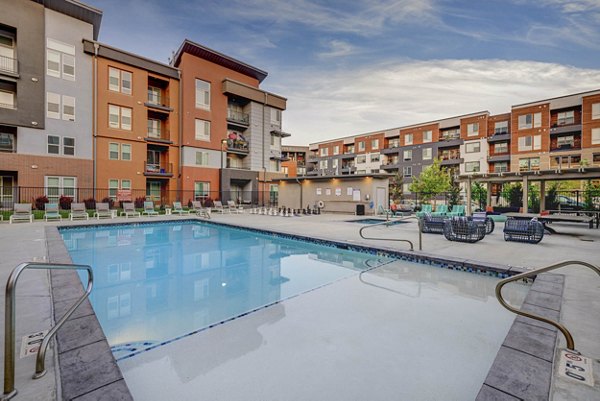 Expansive pool area with loungers at Novi at Jordan Valley Station Apartments, perfect for relaxing and swimming