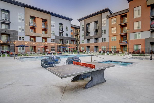 Courtyard featuring modern seating and lush greenery at Novi at Jordan Valley Station Apartments