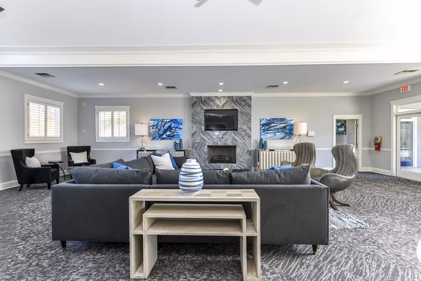 Modern clubhouse with cozy seating and large windows at The Palmer Apartments