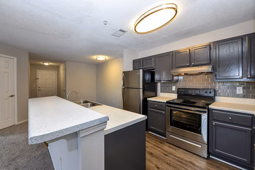 Modern kitchen with granite countertops and stainless steel appliances at The Palmer Apartments