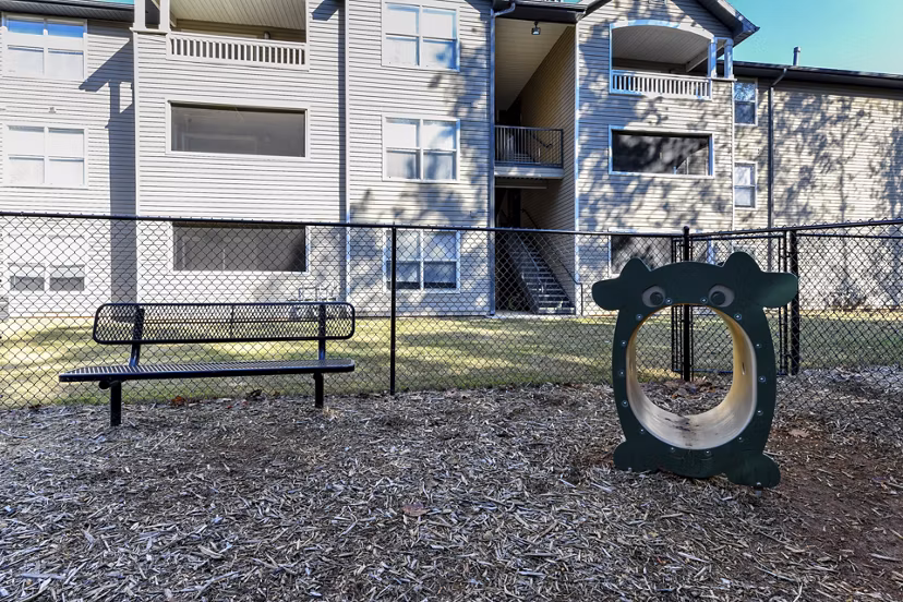Fenced dog park with agility equipment at The Palmer Apartments, perfect for pet owners seeking an active lifestyle in a luxury community