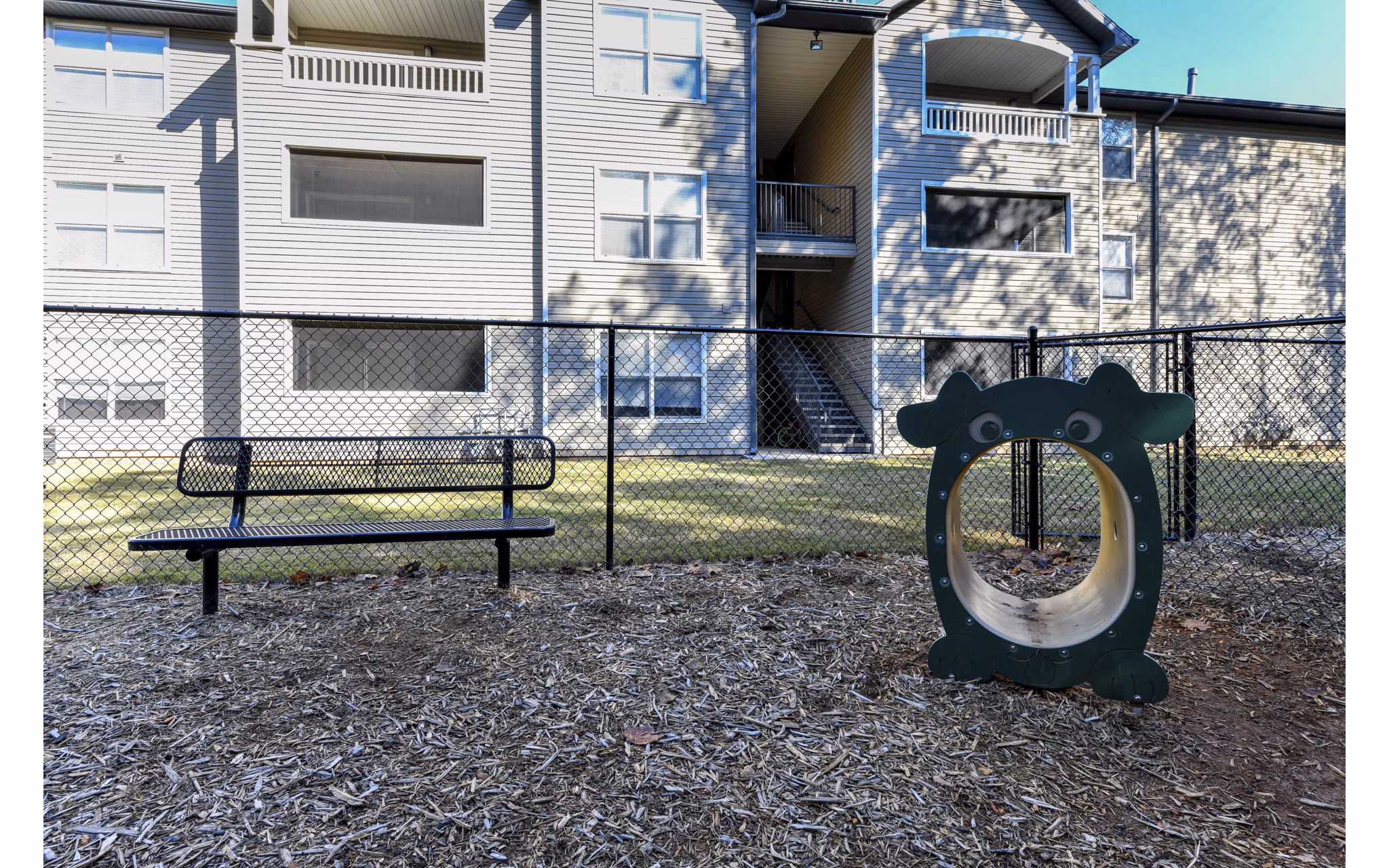 Fenced dog park with agility equipment at The Palmer Apartments, perfect for pet owners seeking an active lifestyle in a luxury community