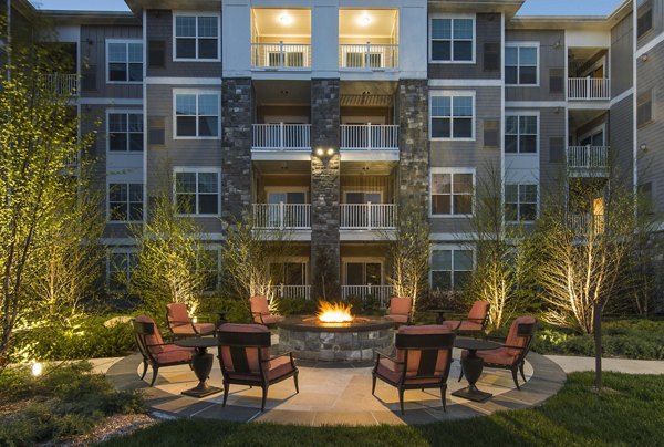 Cozy fire pit area at Marq at the Pinehills Apartments, ideal for social gatherings and relaxation in scenic surroundings