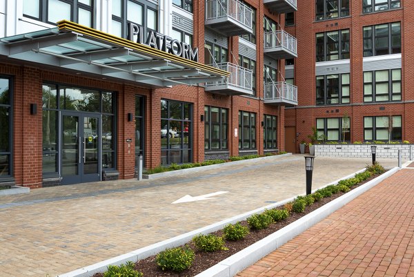 PLATFORM: Sleek modern apartment building with landscaped grounds and balconies in an urban setting