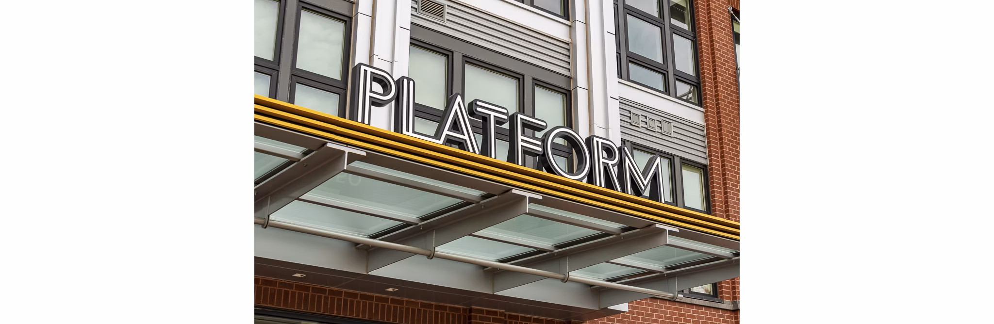 PLATFORM luxury apartments with a glass awning and modern architecture in an urban setting
