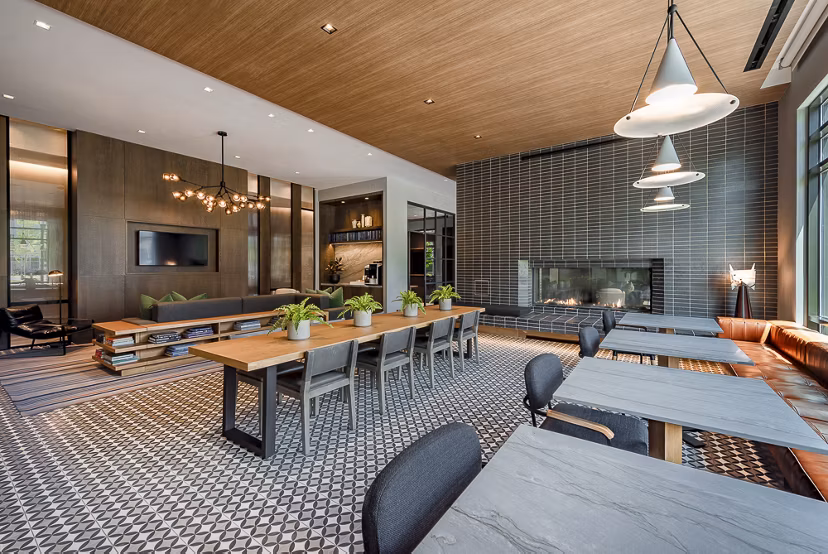Stylish lounge area with tables and chairs, featuring a fireplace and decorative lighting in luxury apartments