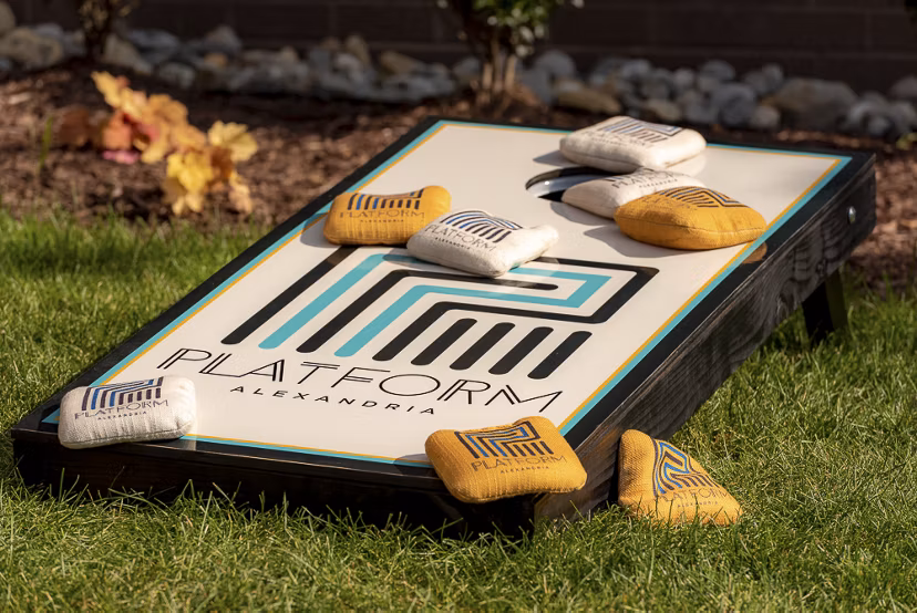 Cornhole board with colorful bean bags set up for a game at luxury apartments