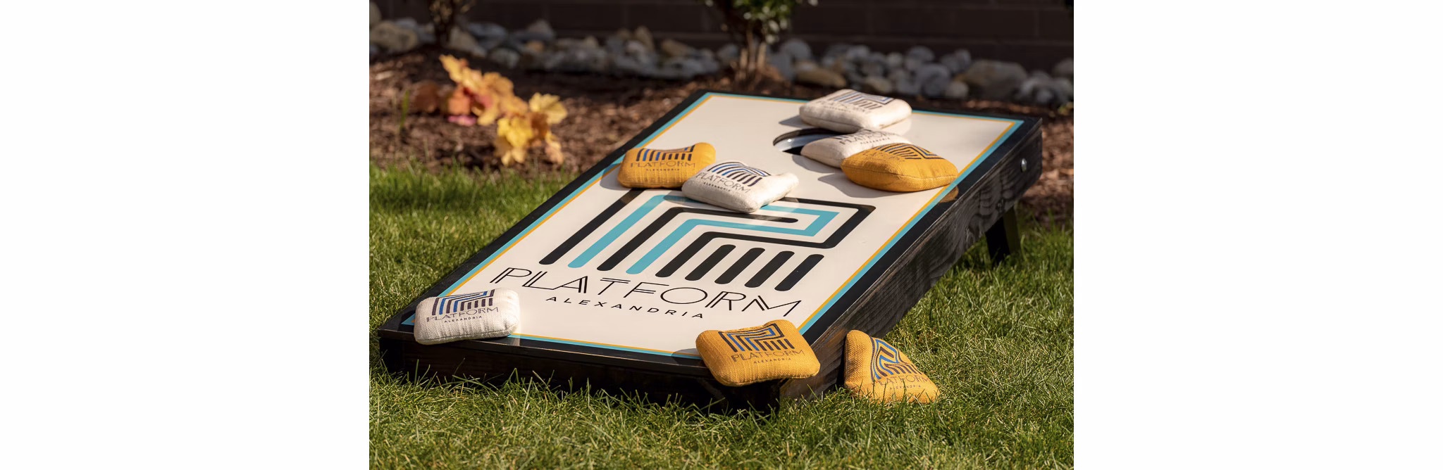 Cornhole board with colorful bean bags set up for a game at luxury apartments