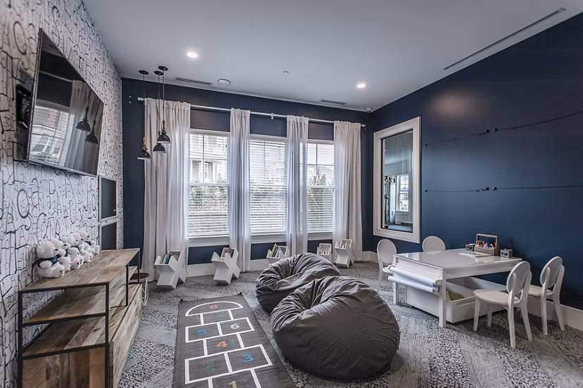 Modern game room with pool table and lounge chairs at Novel Lockwood Glen Apartments