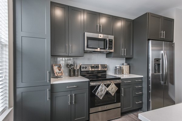 Modern kitchen with stainless steel appliances at Novel Lockwood Glen Apartments, featuring a spacious island and sleek cabinetry for luxury living