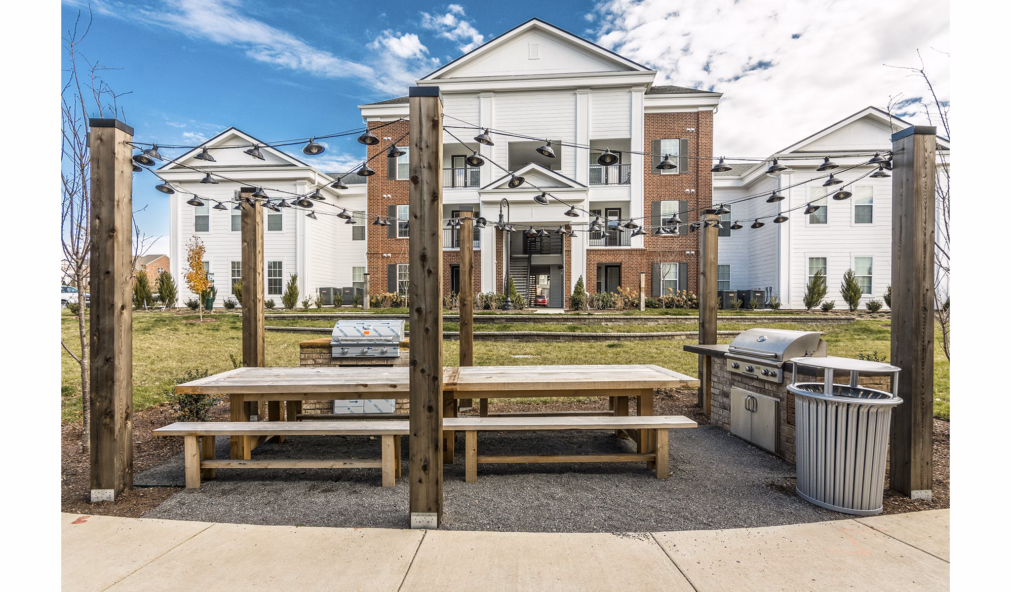 Outdoor dining and grill area at Novel Lockwood Glen Apartments featuring modern BBQ pits and seating for social gatherings
