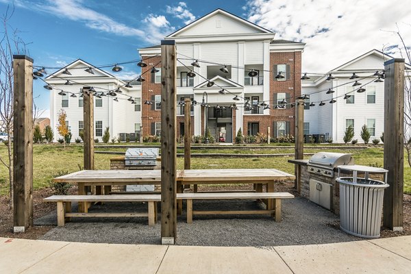 Outdoor dining and grill area at Novel Lockwood Glen Apartments featuring modern BBQ pits and seating for social gatherings