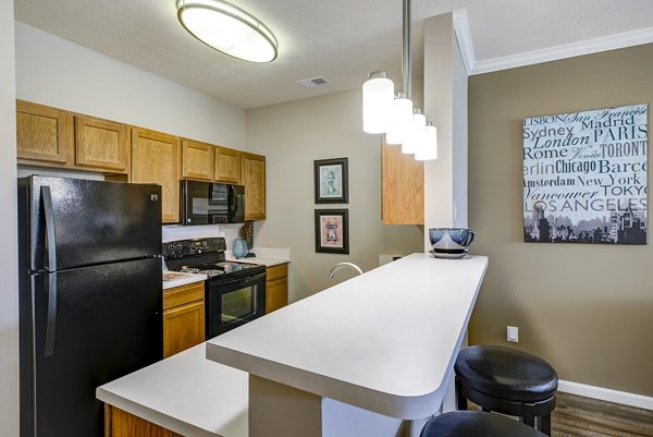 Contemporary kitchen with sleek appliances and granite countertops at Summit Pointe Apartments