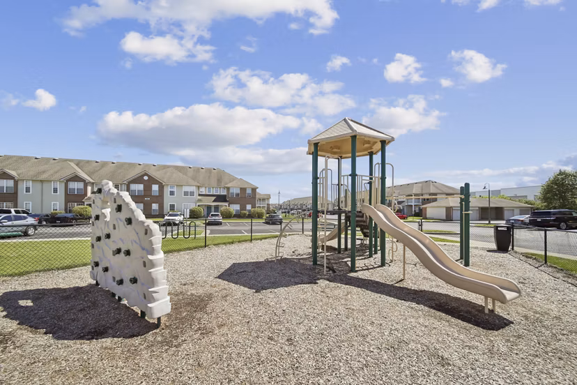 Modern playground for children at Summit Pointe Apartments with slides and swings
