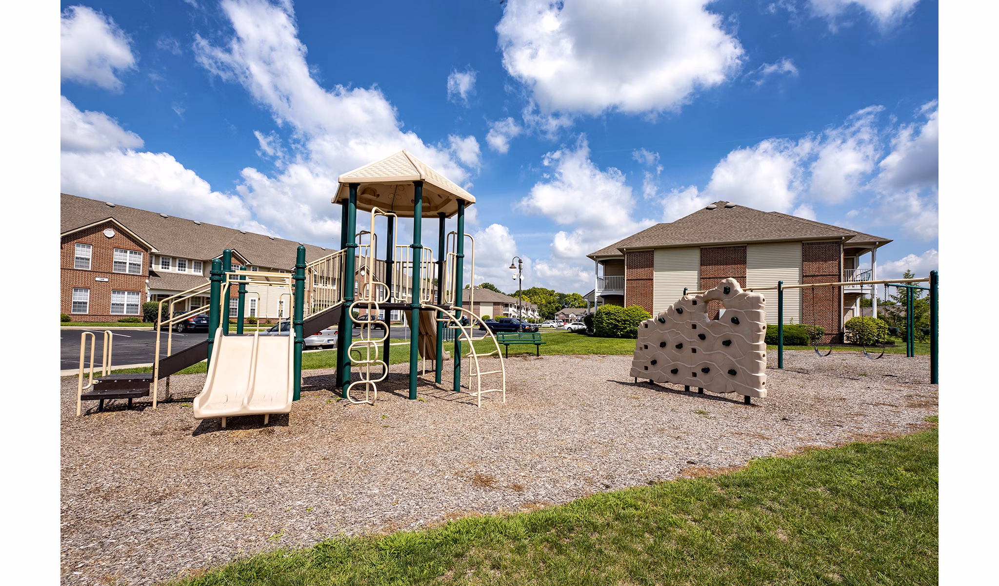 Modern playground for children at Summit Pointe Apartments with slides and swings