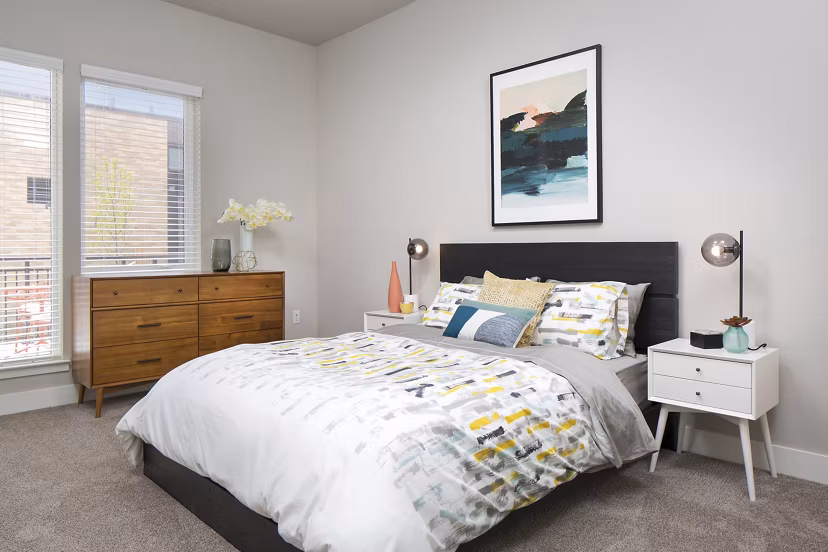 Elegant bedroom featuring modern decor and plush bedding at The Glenn Apartments Discover luxury living in a serene setting