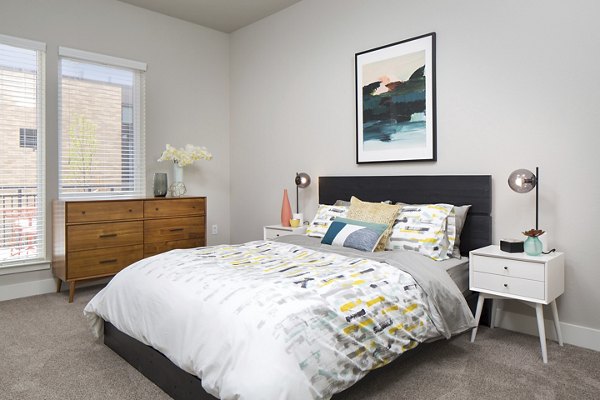 Elegant bedroom featuring modern decor and plush bedding at The Glenn Apartments Discover luxury living in a serene setting