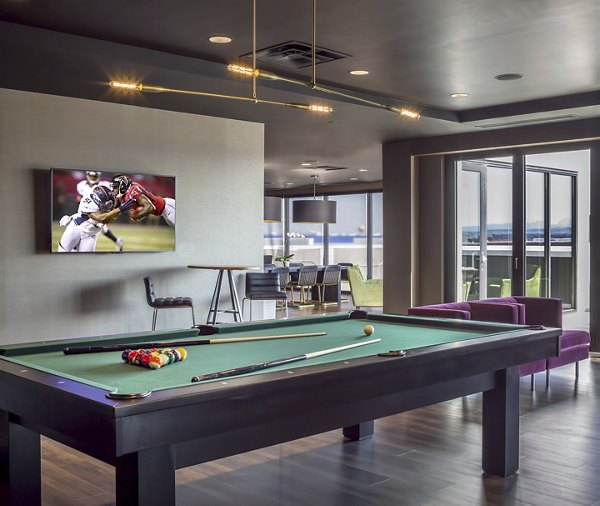 Lounge area featuring a pool table and large TV with a sports game