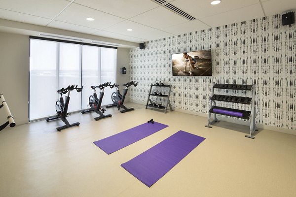 Modern yoga/spin studio with natural light at The Glenn Apartments, offering luxury fitness facilities