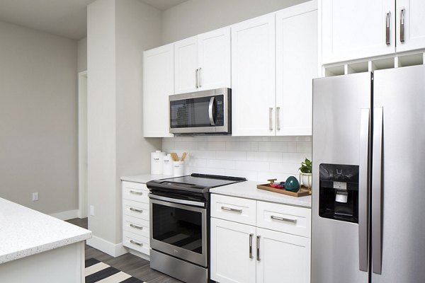 Modern kitchen with sleek countertops and stainless steel appliances at The Glenn Apartments