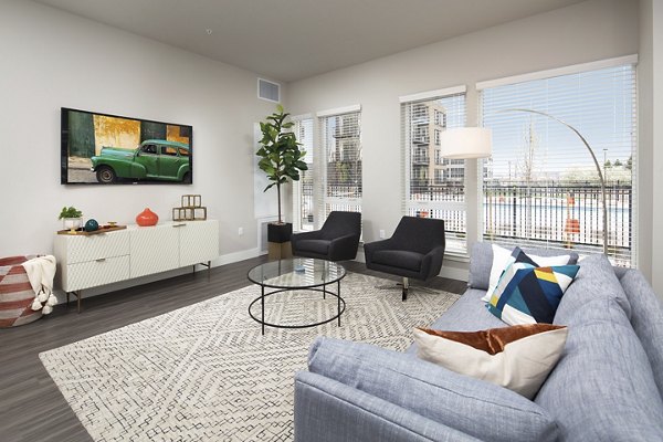 Spacious living room featuring modern design and large windows at The Glenn Apartments, luxury homes by Greystar