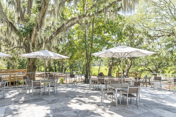 Charming courtyard with seating and lush greenery at Overture West Ashley Apartments