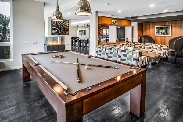 Clubhouse game room with pool table and seating at AV8 Apartments