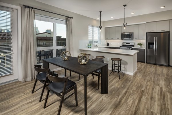 Dining area with modern lighting and sleek furniture at AV8 Apartments